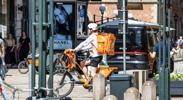 Lieferando-Bote fährt mit Fahrrad und Rucksack durch die Stadt