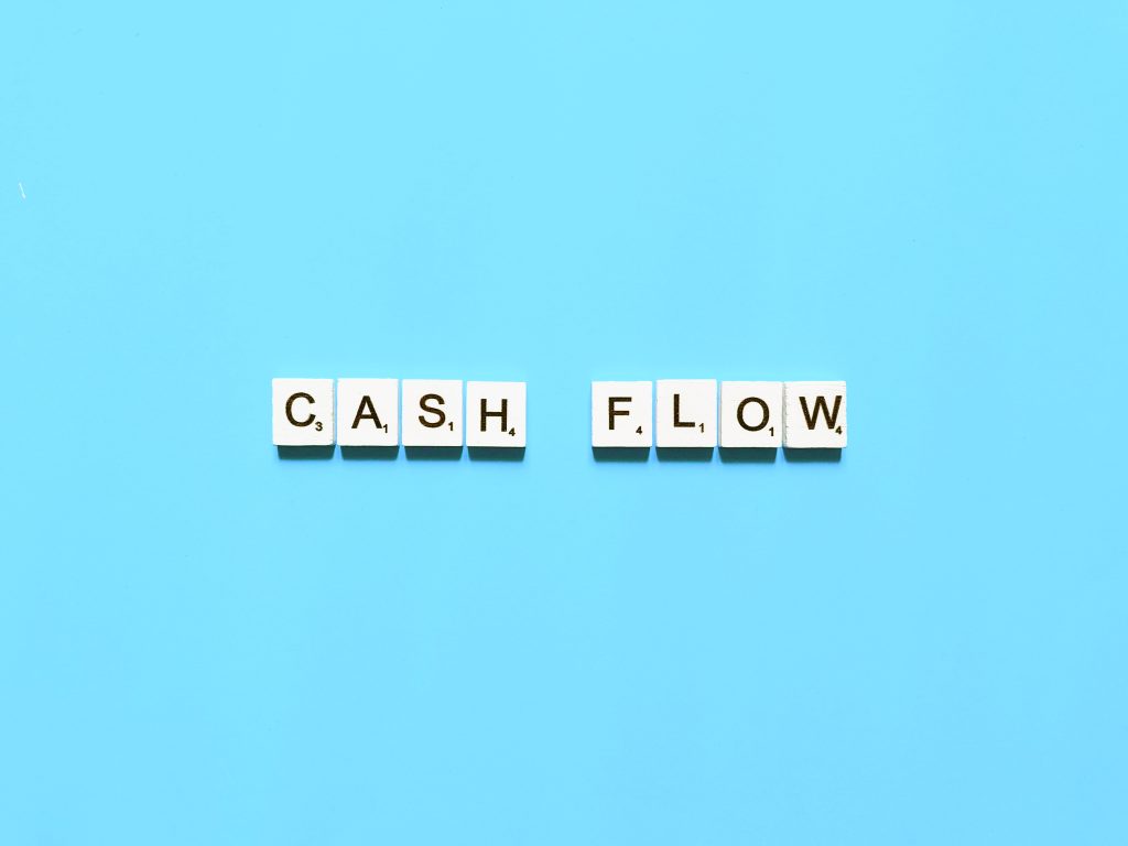 Cashflow in Blockbuchstaben auf blauem Hintergrund