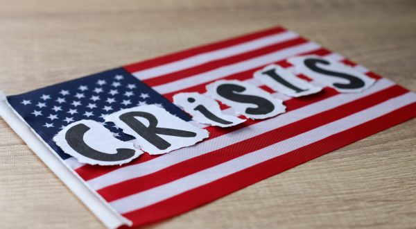 CRISIS in Buchstaben auf die amerikanische Flagge aufgelegt