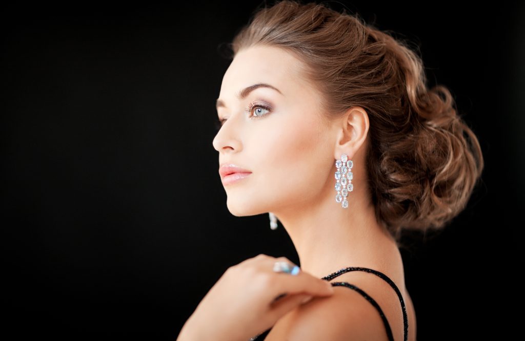 Frau trägt elegante Diamanten-Ohrringe