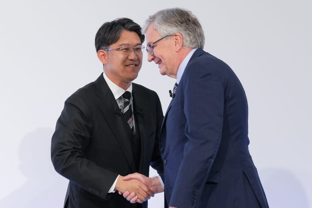 Martin Daum, Vorstand von Daimler Trucks und Koji Sato, Präsident von Toyota Motor geben sich die Hand. 