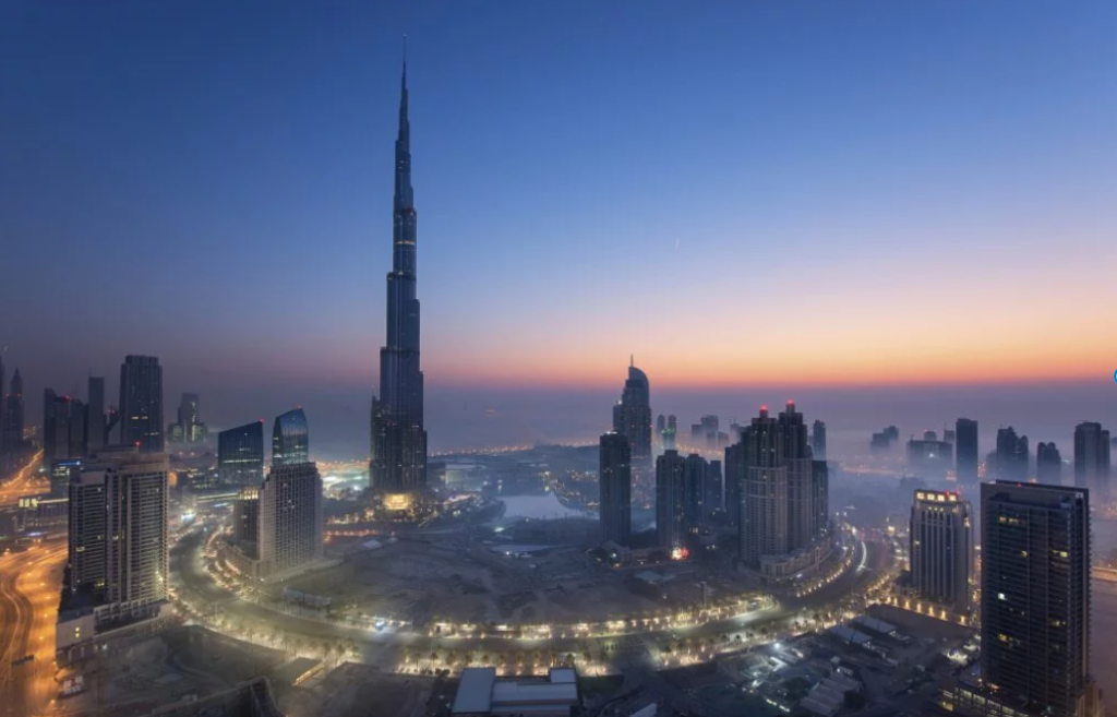 Stadtbild von Dubai, Vereinigte Arabische Emirate in der Abenddämmerung, mit dem Wolkenkratzer Burj Khalifa und beleuchtet
