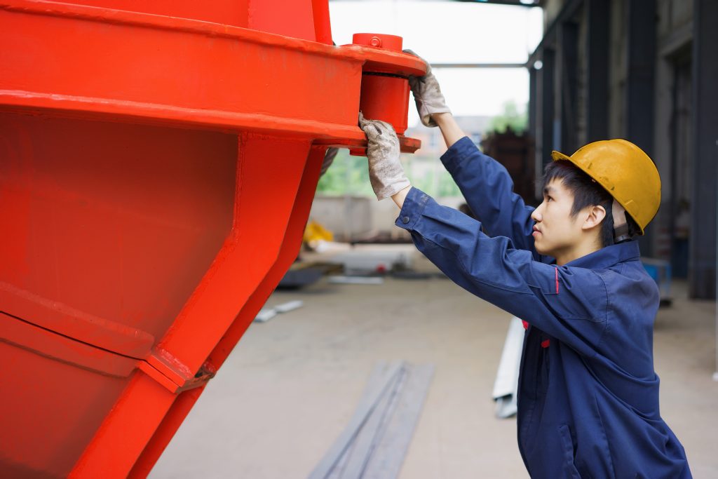 Chinesischer Arbeiter stützt Container