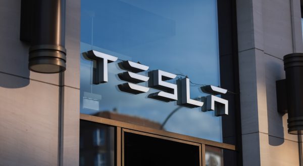 Logo von Tesla über einem Eingang auf blauem Glas