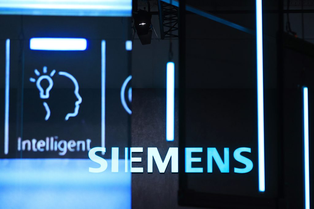 Logo von Siemens in Blau-weiß dahinter das Wort Intelligent und ein skizzierter Kopf der an der Rückseite eine Glühbirne hat