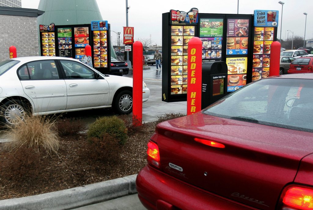 Zwei Autos fahren durch die Drive-Thru-Anlage bei McDonald's