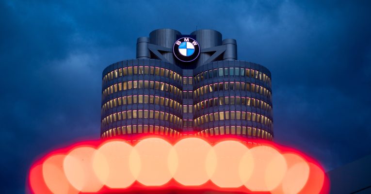 Logo von BMW auf einem Firmengebäude. Davor ein roter Bogen