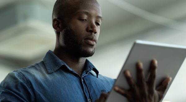 Mann hält Tablet in der Hand